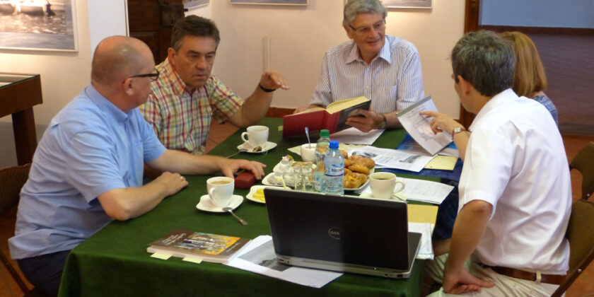 Na zdjęciu grupa osób dyskutujących przy stole